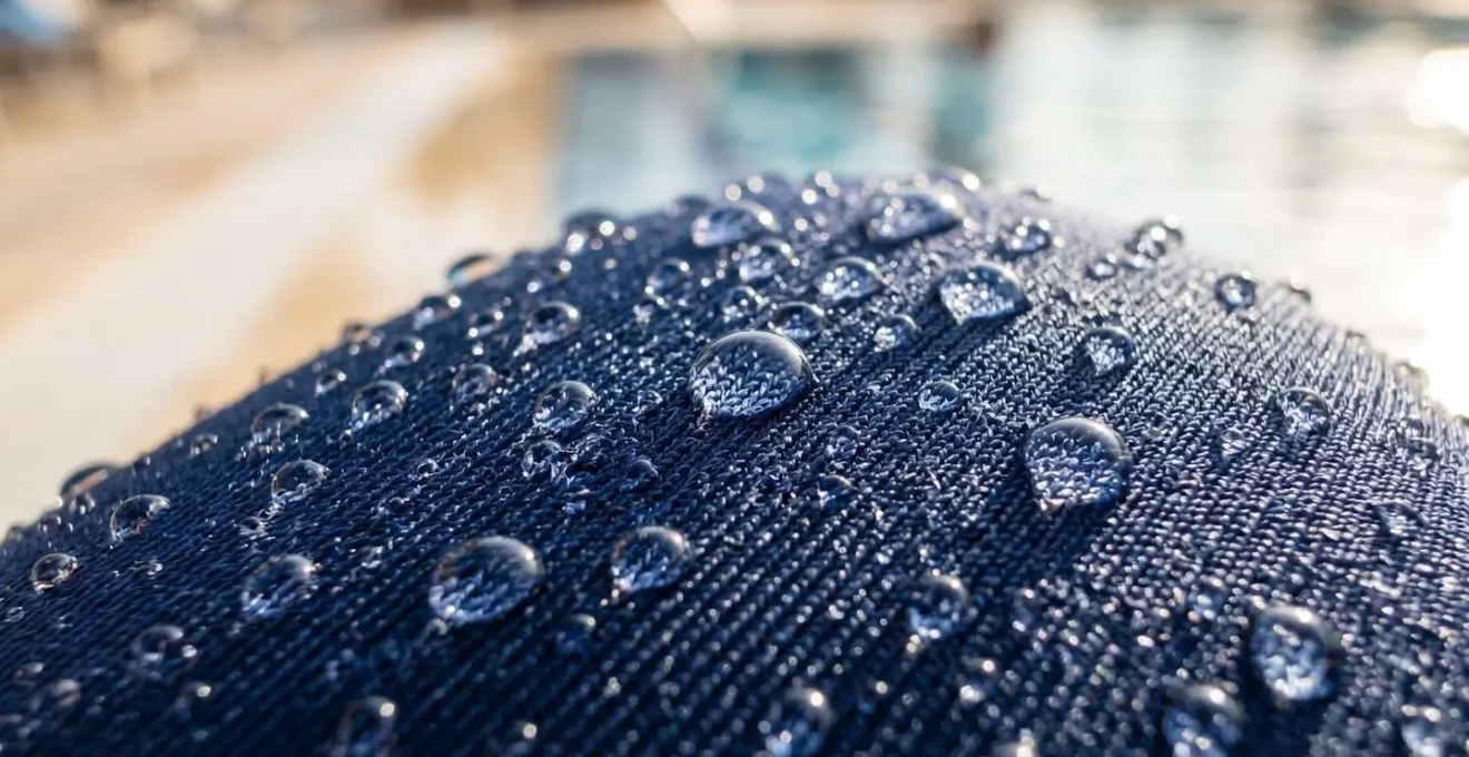 Gros plan extrême sur la texture d'un tissu de burkini en élasthanne avec des gouttes d'eau perlant sur les fibres